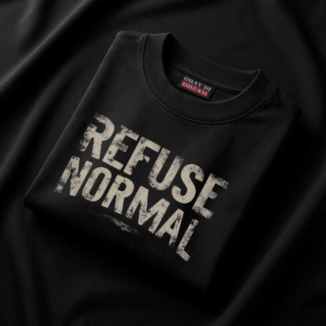 Enzyme-washed black OBAY DI DREAM Refuse Normal t-shirt folded on a dark surface with distressed text graphic
